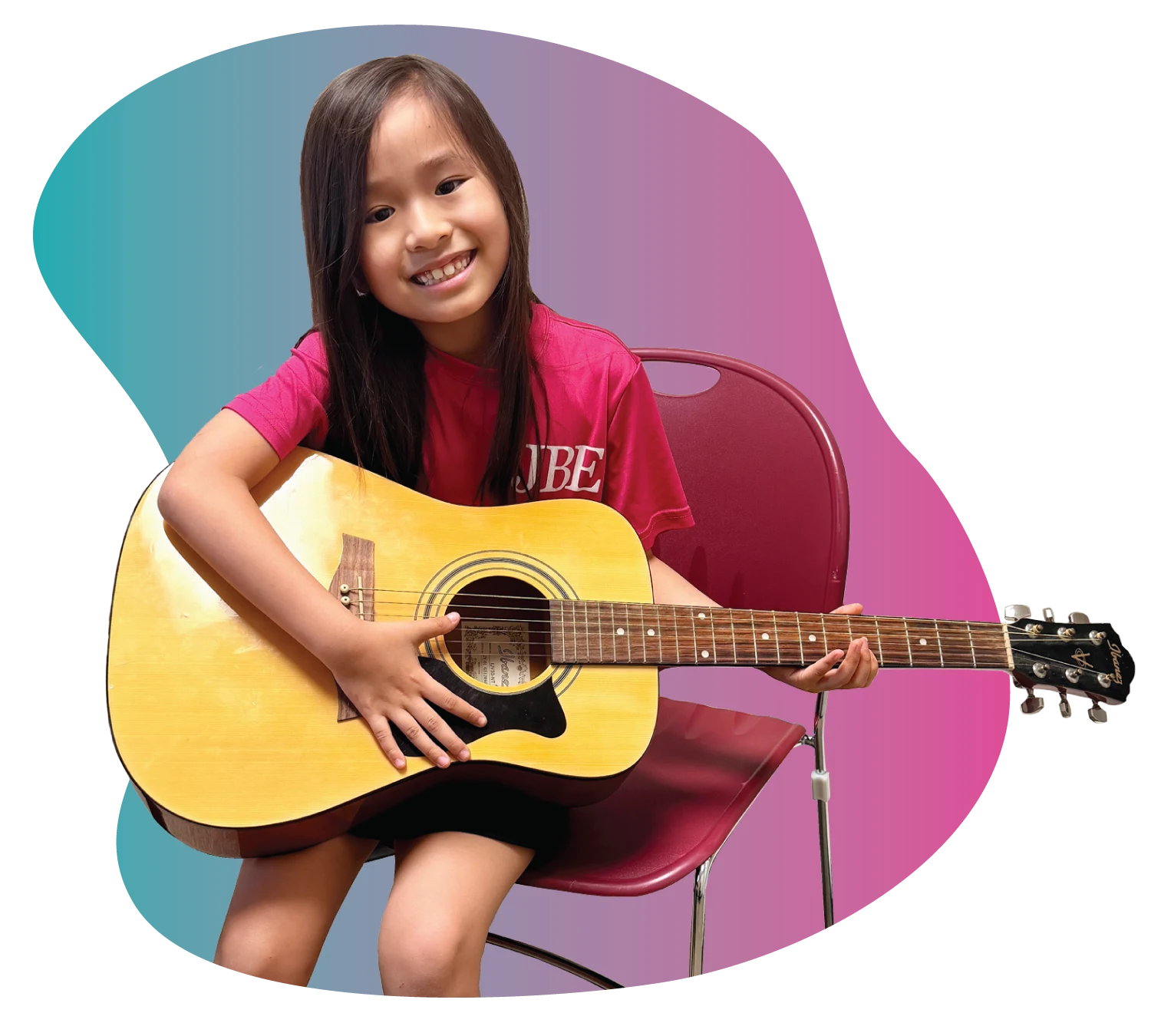 Student Spotlight - Guitar Discovery A smiling young girl holding a guitar during her music lessons at FAME in Mount Pleasant.