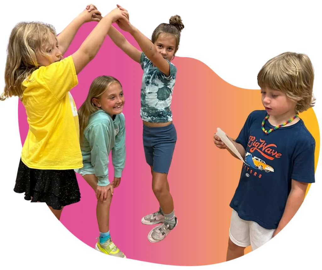 Young students forming an arm archway while a boy reads from a script in a co-ed group acting class at FAME.