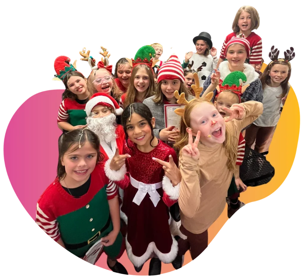 What is Jr Troupe at FAME Performing Arts Large group of young performers in festive holiday costumes and antler headbands posing happily during a FAME Jr Troupe show.
