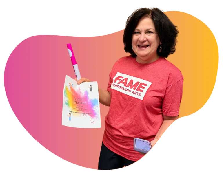 FAME flute instructor holding a pink beginner Toot flute instrument and printed music curriculum sheet during a private lesson.