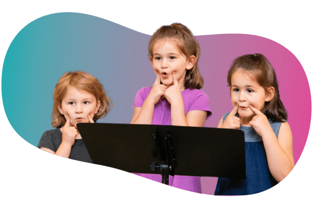 Student Spotlight - WonderStage Joy A smiling young girl holding soft pink poms during preschool music lessons at FAME Performing Arts in Mount Pleasant.